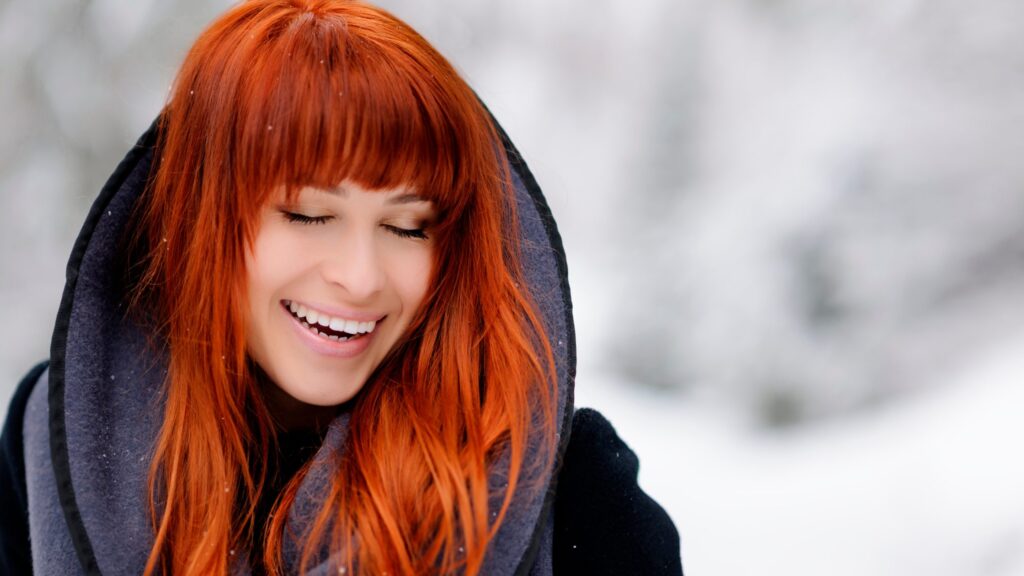 A Woman Smiling With Bright Red Hair